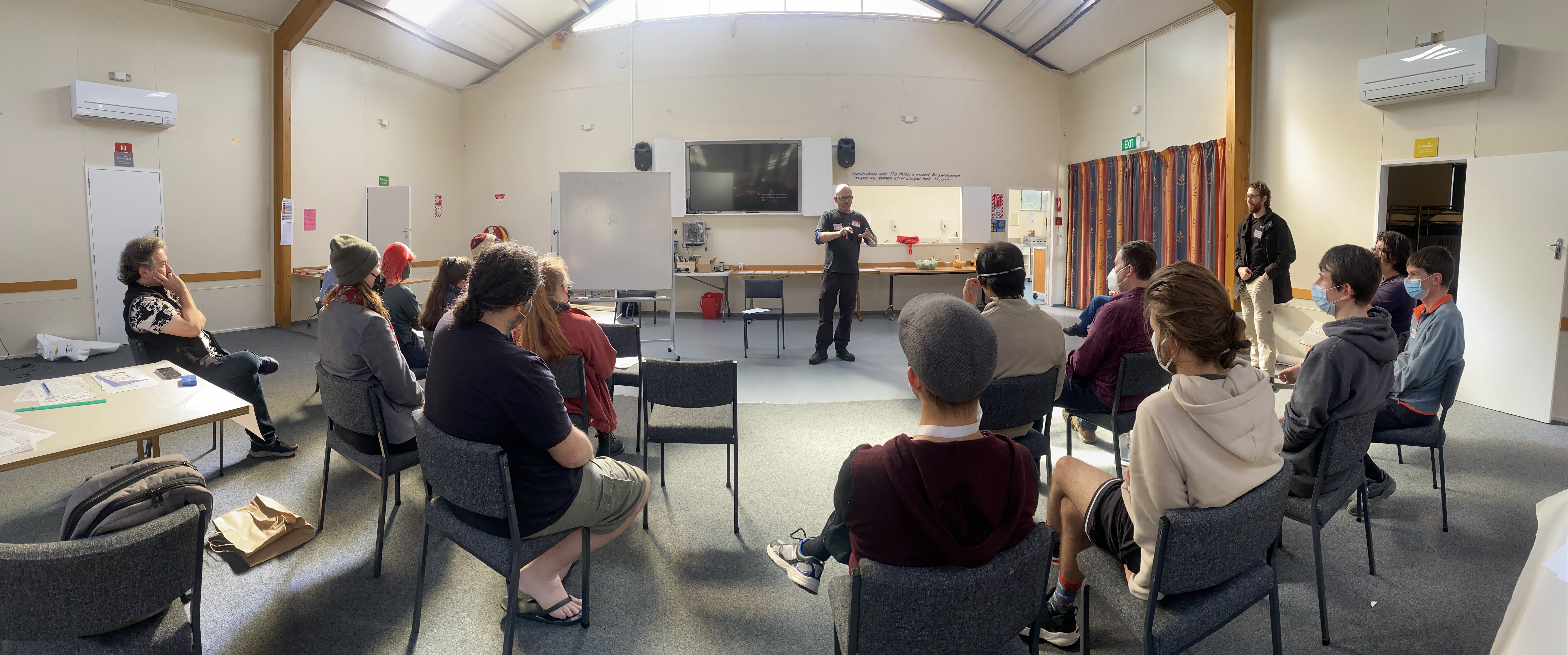 wide shot of Tom giving an Open Mic Maths Talk, with audience watching
